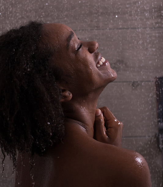 A woman taking a exilarating self care shower.