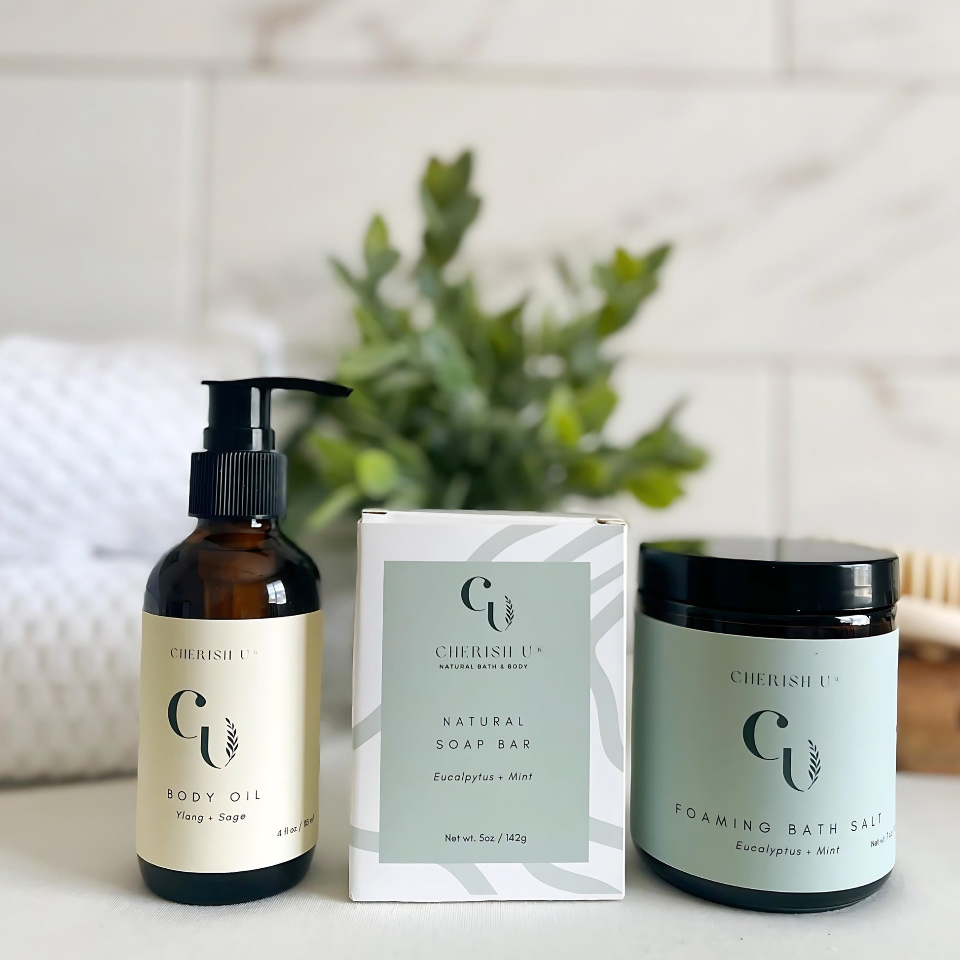Elegant display of the Breathe Spa Bath Set with Eucalyptus + Mint Soap, Foaming Bath Salt, and Ylang + Sage Body Oil in amber containers, offering a refreshing and rejuvenating spa experience.