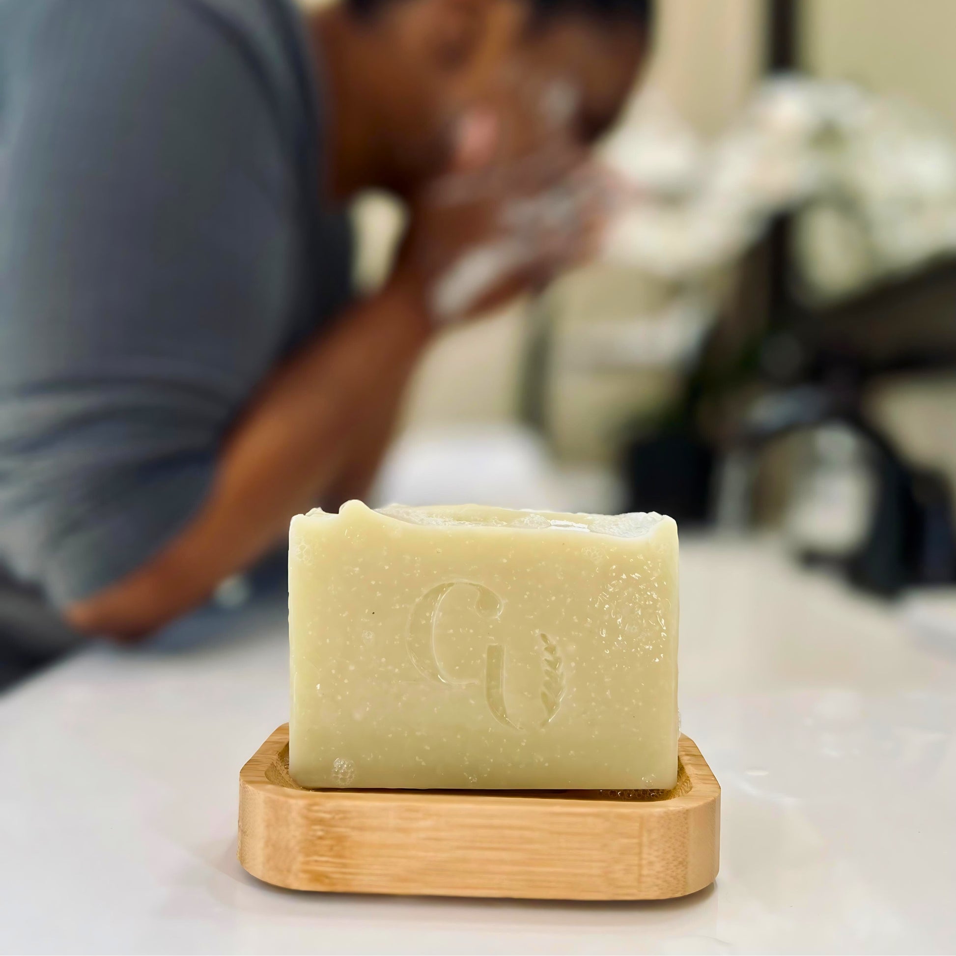 "A person lathers and washes face with handcrafted French green clay soap, enriched with tea tree and lavender essential oils, for a soothing and natural cleanse."