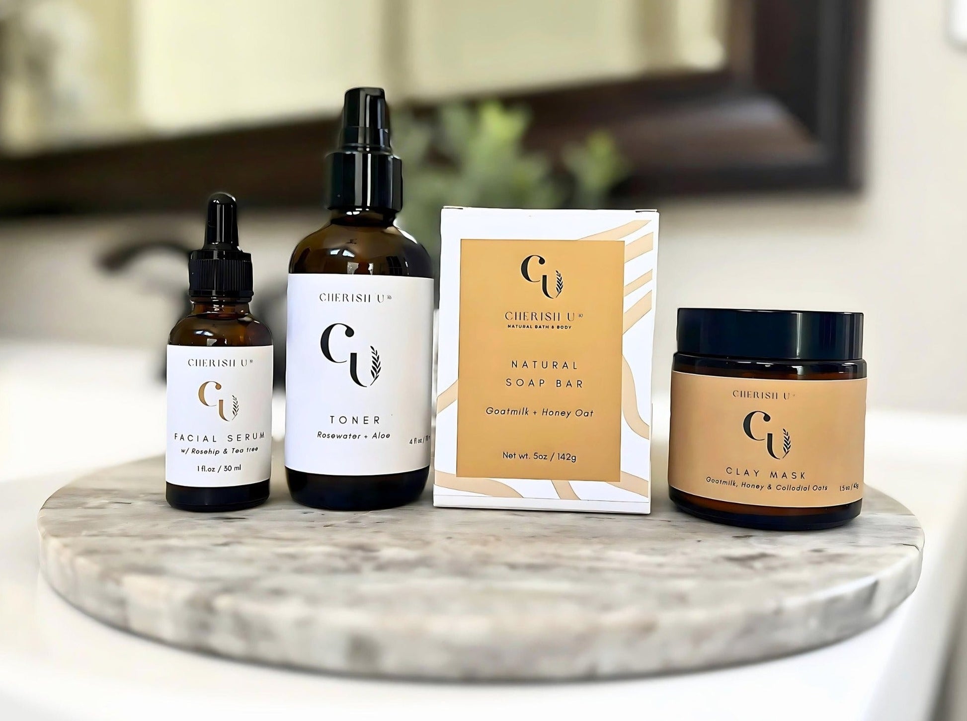 A nourishing skincare set featuring a goat milk + honey oat soap, goat milk + honey oat mask, rosewater + aloe toner, and facial serum with rosehip and tea tree oil on a bathroom vanity.