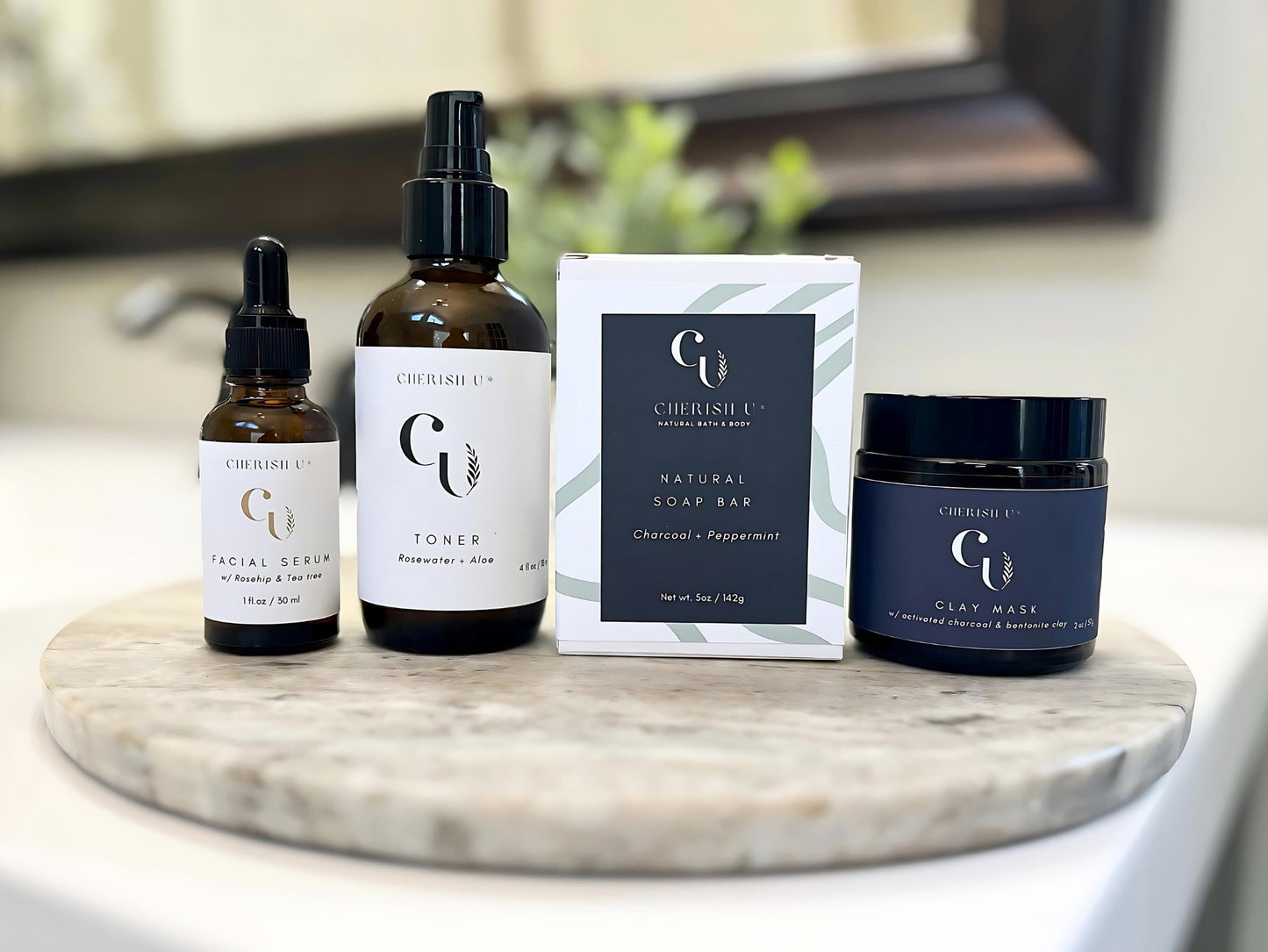 A detoxifying skincare set featuring a charcoal peppermint soap, charcoal + bentonite clay mask, rosewater + aloe toner, and facial serum with rosehip and tea tree oil. Cherish U®