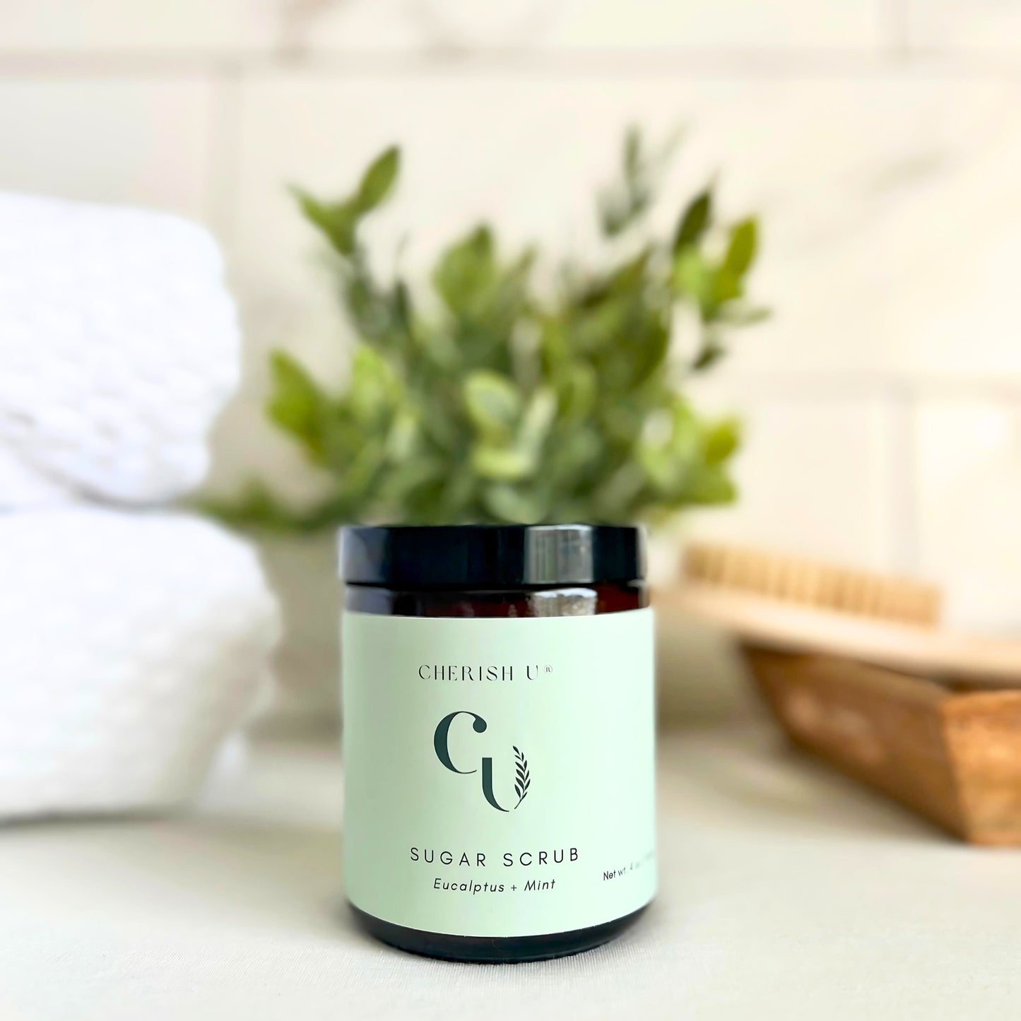 Amber jar of Eucalyptus + Mint Sugar Scrub, designed to exfoliate and refresh the skin with invigorating eucalyptus and mint." Cherish U®