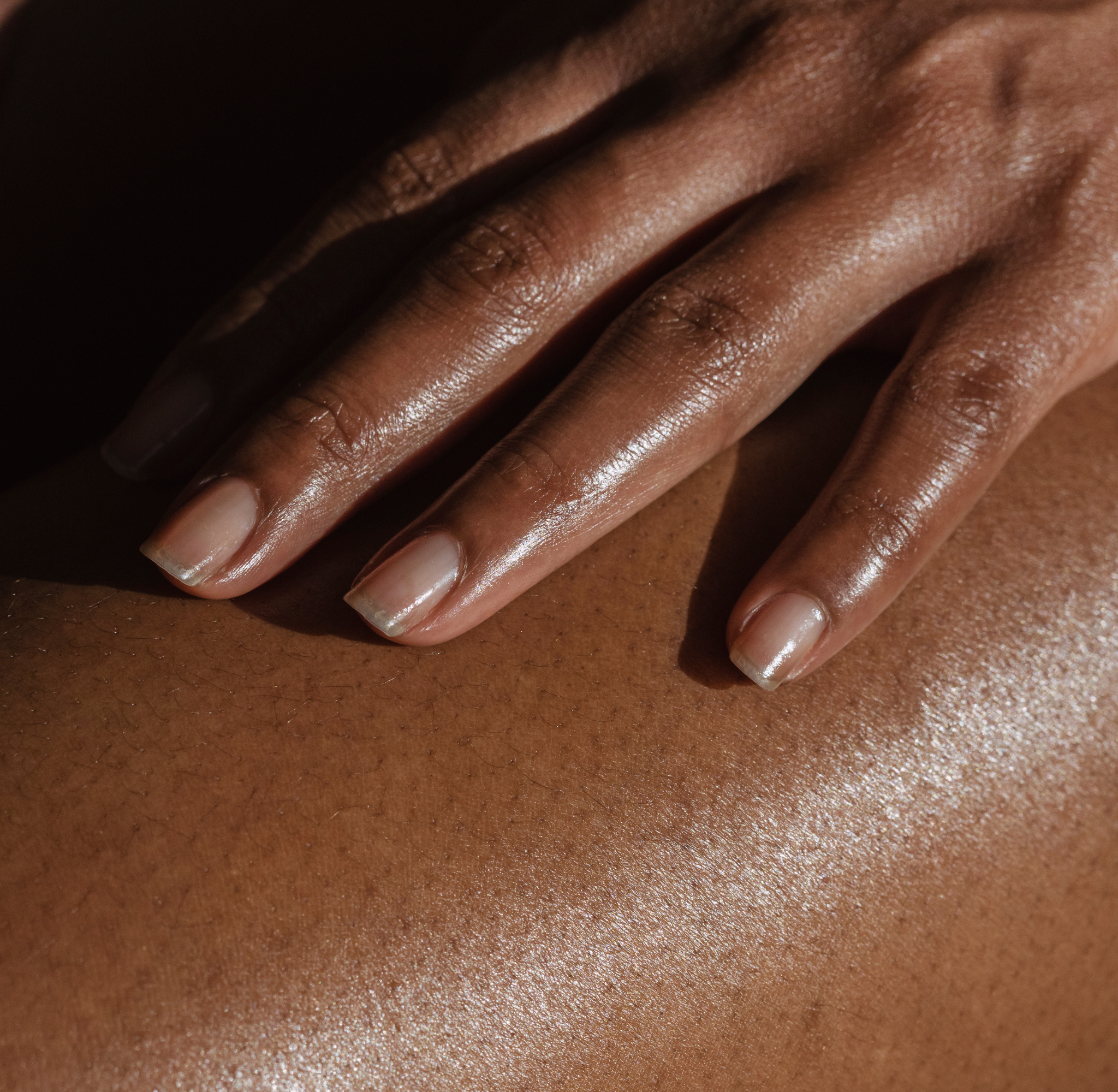 woman applying body oil to skin