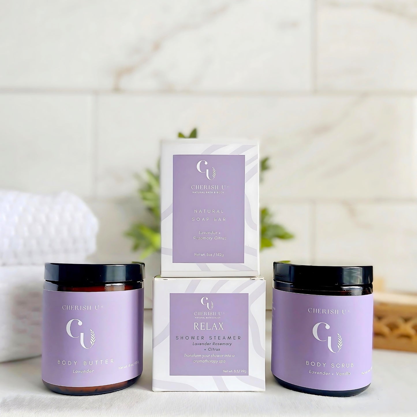 A spa shower gift set featuring Lavender Rosemary + Citrus soap and shower steamer, Lavender + Vanilla sugar scrub, and Lavender body butter for a relaxing, soothing experience." Cherish U®